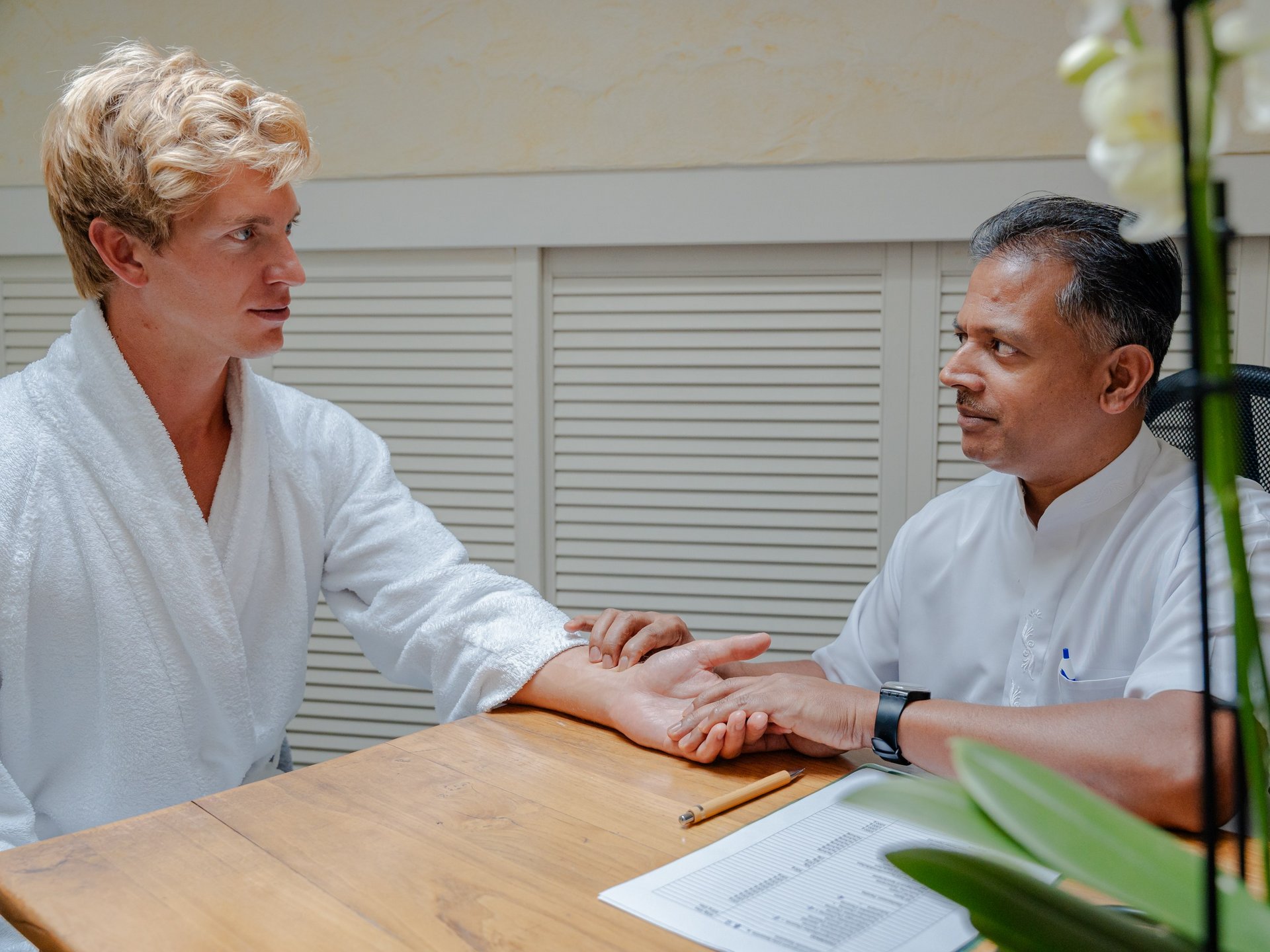 Beratungsgespräch und Pulsdiagnose bei einem Experten in der Ayurveda-Abteilung des Hotels Vier Jahreszeiten.