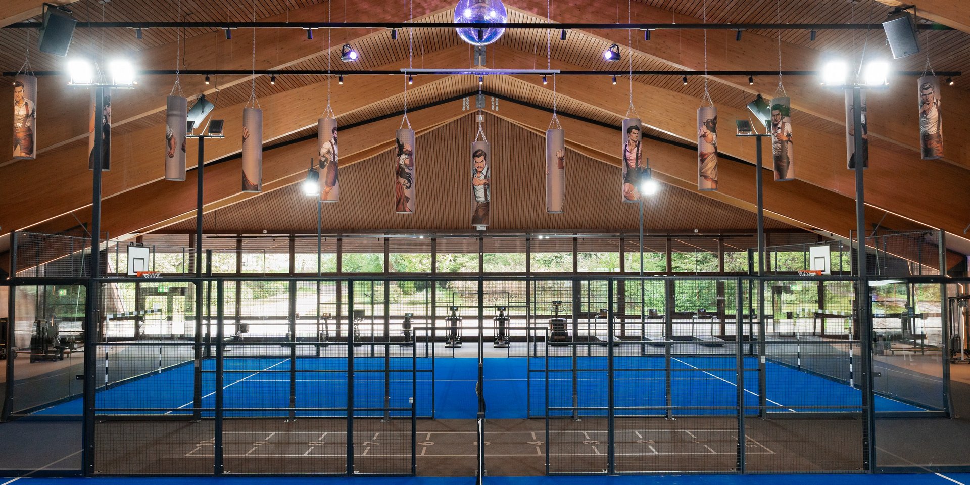 Professionelle Padel-Anlage mit Glaswänden und heller Beleuchtung für Hotelgäste.