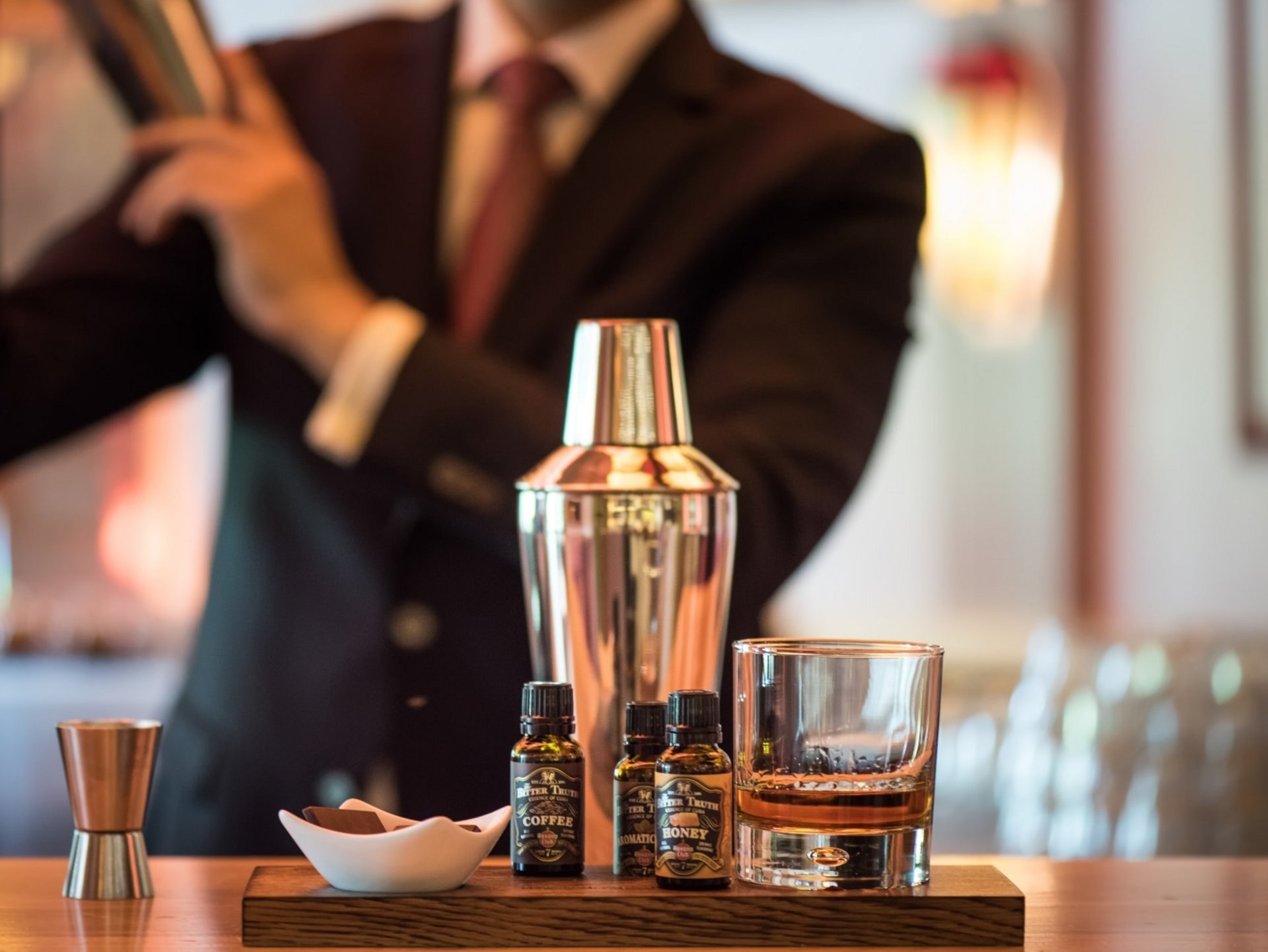 Ein Barkeeper mixt einen Drink vor der Kulisse der hoteleigenen Bar im Hotel Vier Jahreszeiten.