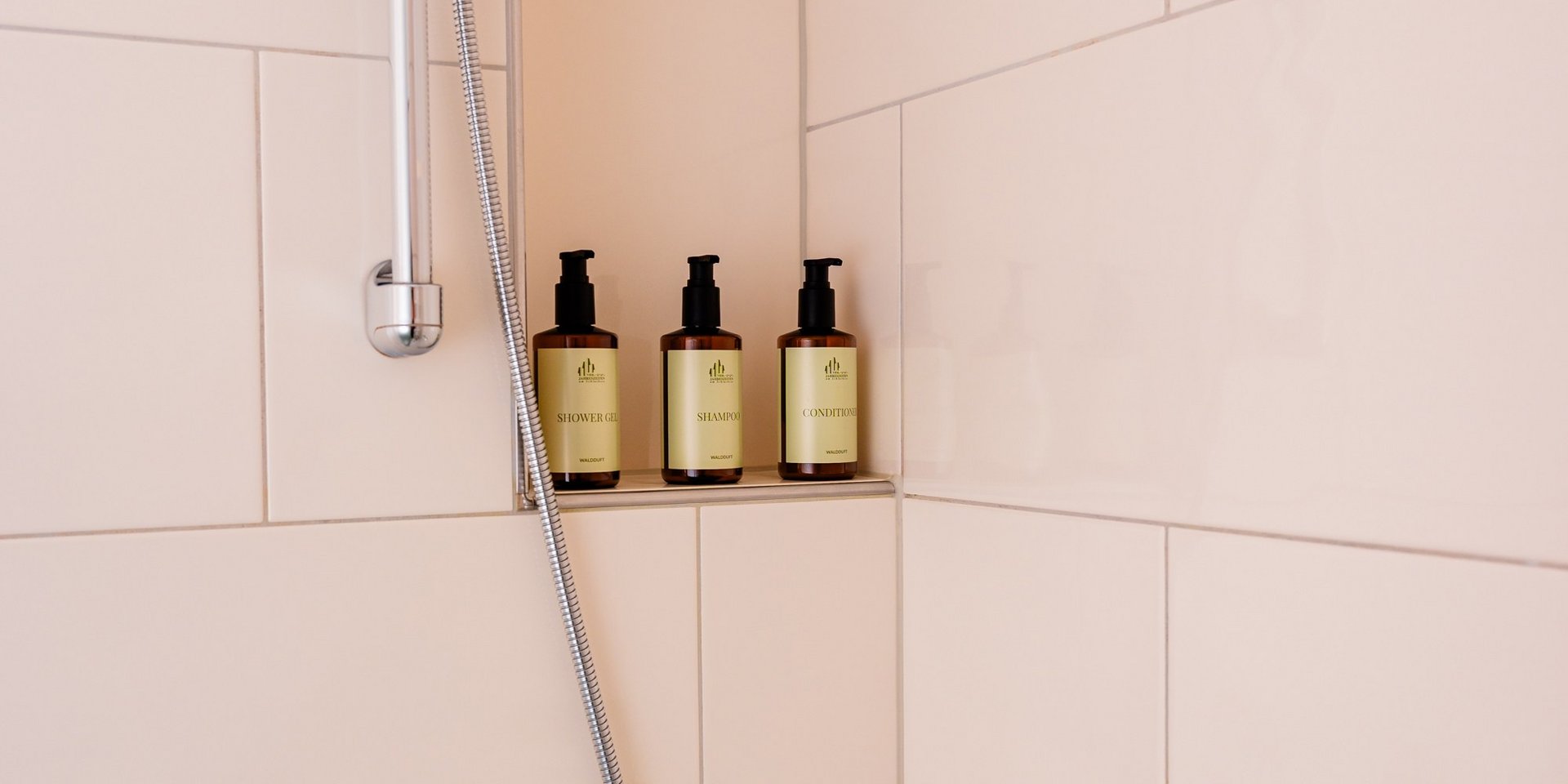 Moderne Dusche mit hellen Fliesen und hochwertigen Pflegeprodukten im Hotel Vier Jahreszeiten am Schluchsee.