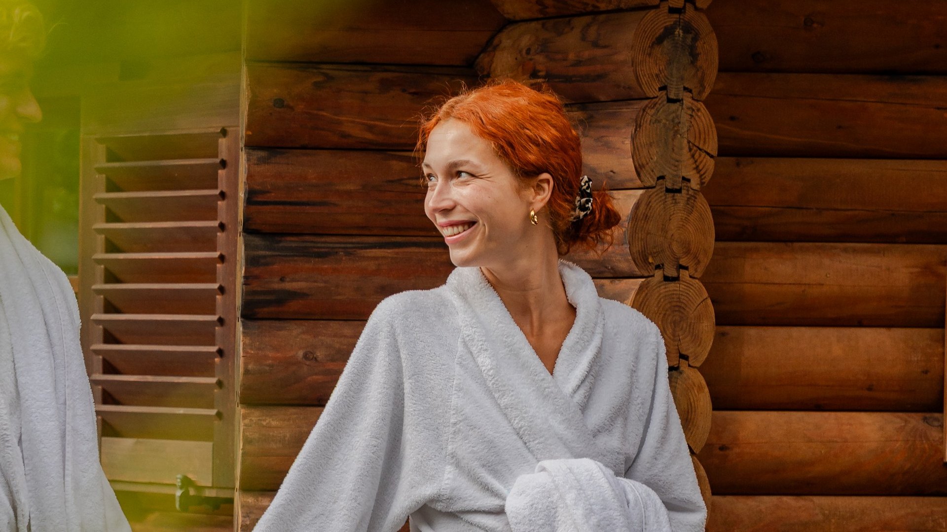 Entspannter Moment nach dem Saunagang: Eine Frau wandelt im Bademantel durch den Wellnessgarten des Hotels.