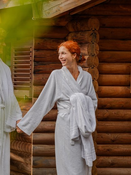 Entspannter Moment nach dem Saunagang: Eine Frau wandelt im Bademantel durch den Wellnessgarten des Hotels.