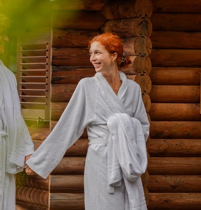 Entspannter Moment nach dem Saunagang: Eine Frau wandelt im Bademantel durch den Wellnessgarten des Hotels.