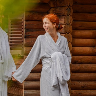 Entspannter Moment nach dem Saunagang: Eine Frau wandelt im Bademantel durch den Wellnessgarten des Hotels.