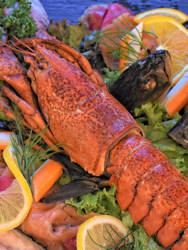 Ein frisch zubereiteter Hummer, garniert mit Zitronen und Kräutern, serviert im Hotel Vier Jahreszeiten.