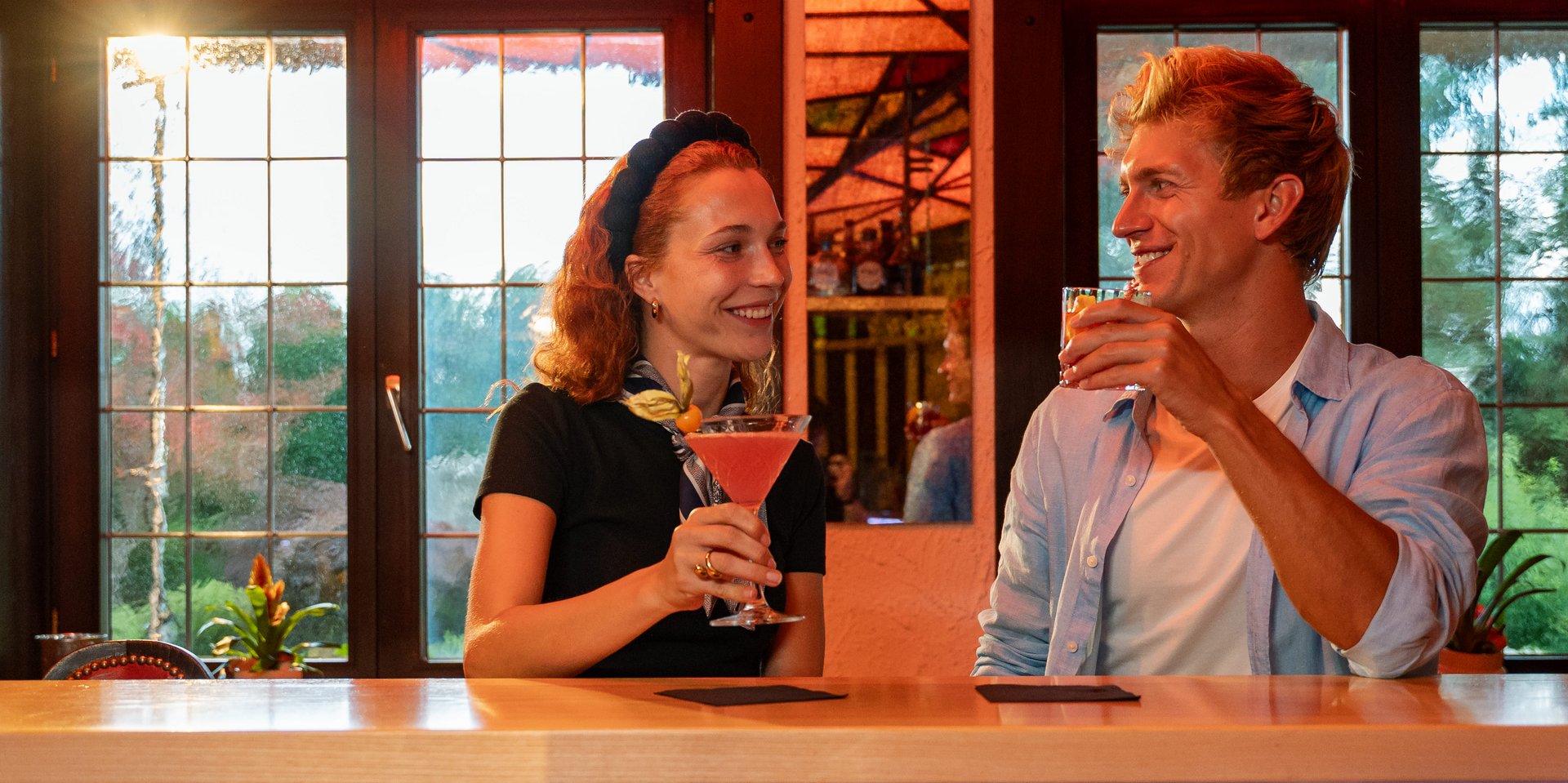 Ein Paar genießt entspannt bunte Cocktails in der modernen Bar-Atmosphäre im Schwarzwald.