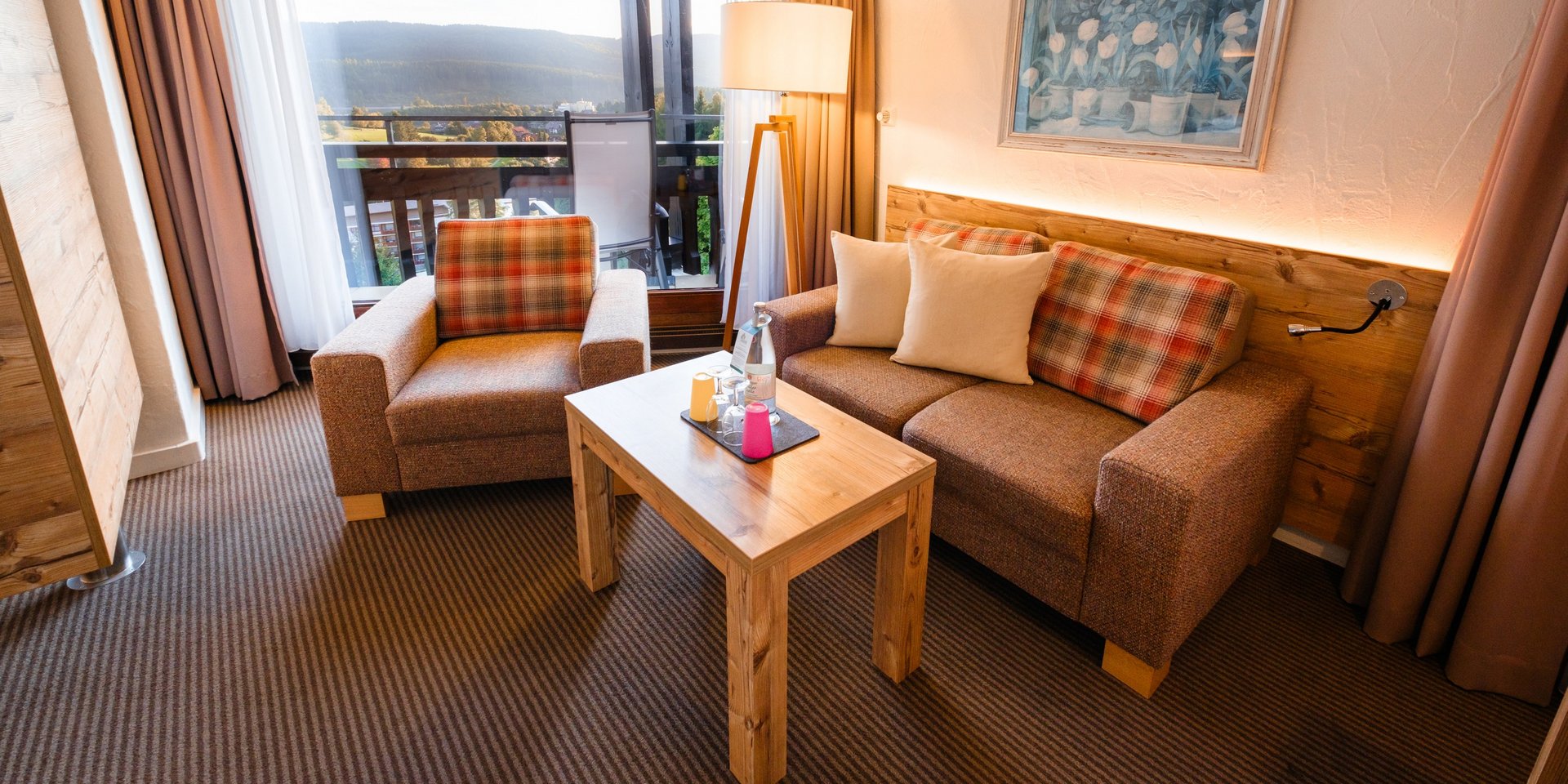 Großzügiger Wohnbereich im Familienapartment Süd mit gemütlicher Couch im Hotel Vier Jahreszeiten am Schluchsee.