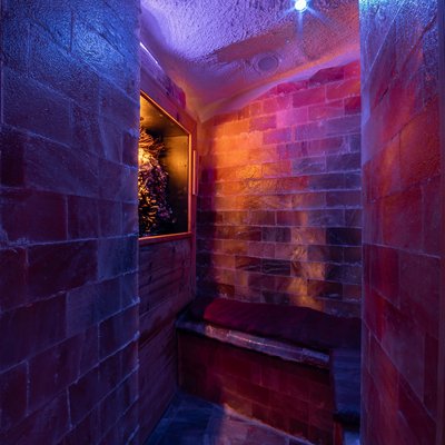 Stimmungsvoll beleuchteter Ruhebereich mit violettem Licht in der Saunalandschaft des Hotels.