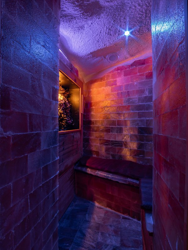 Stimmungsvoll beleuchteter Ruhebereich mit violettem Licht in der Saunalandschaft des Hotels.