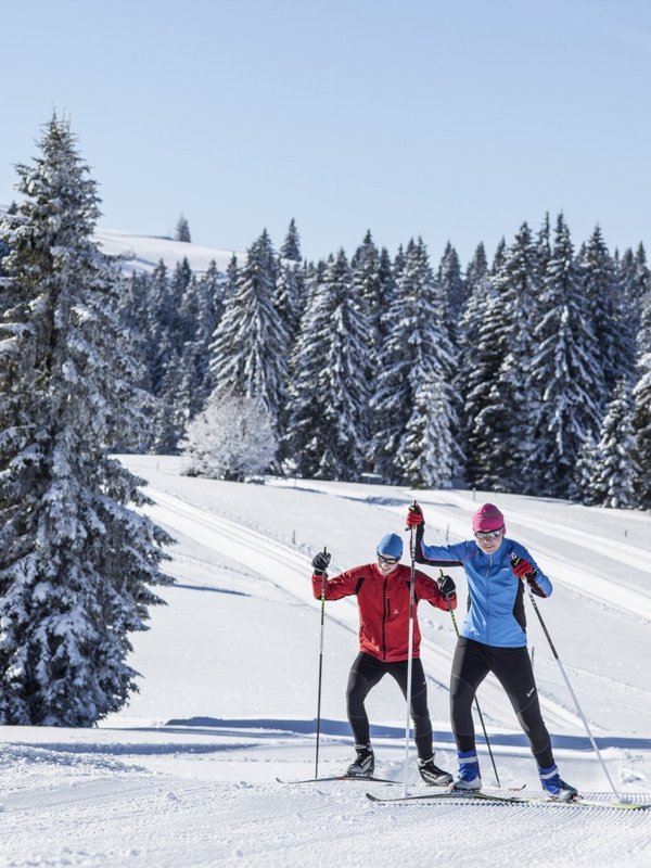 Zwei Personen beim Skilanglauf auf einer bestens gespurten Loipe durch den Schwarzwald.