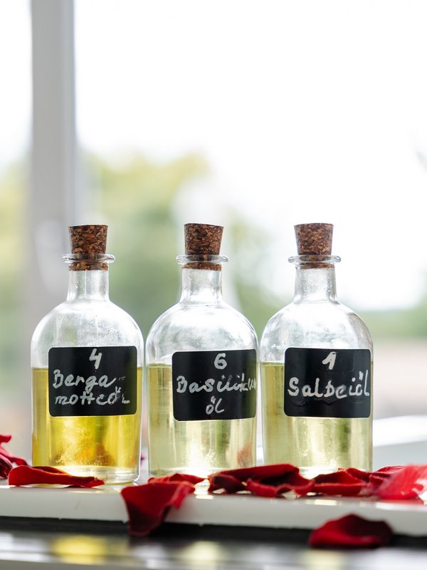 Hochwertige Massageöle und Rosenblüten bereiten den Gast auf die Behandlung im Hotel Vier Jahreszeiten vor.