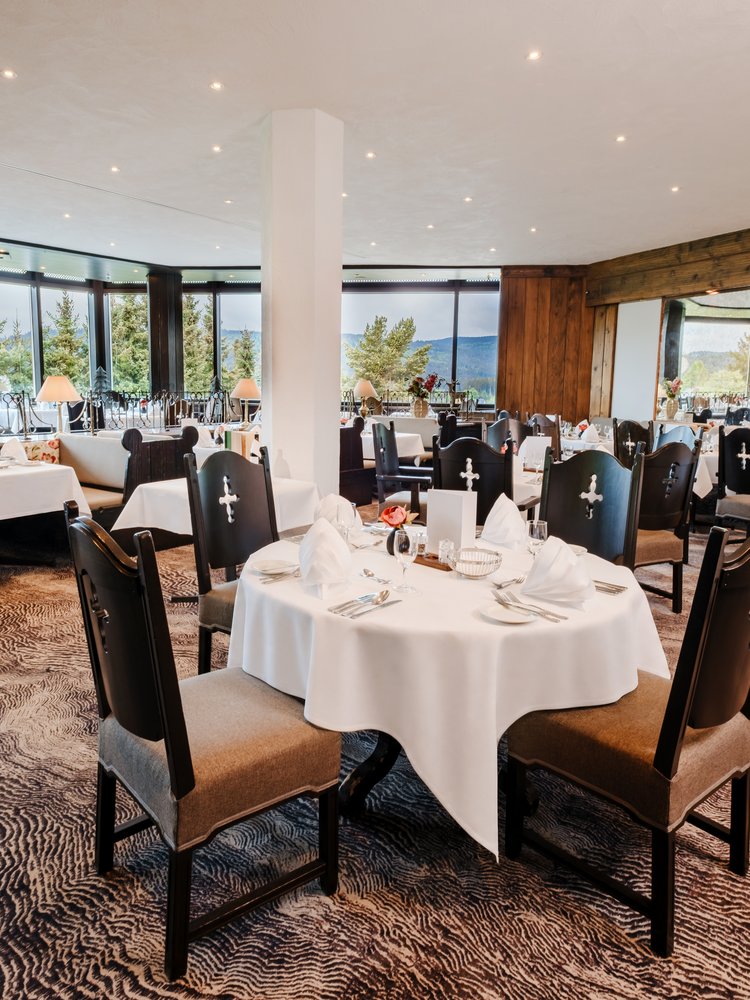 Blick in das Panoramarestaurant mit eingedeckten Tischen in Richtung Fensterfront