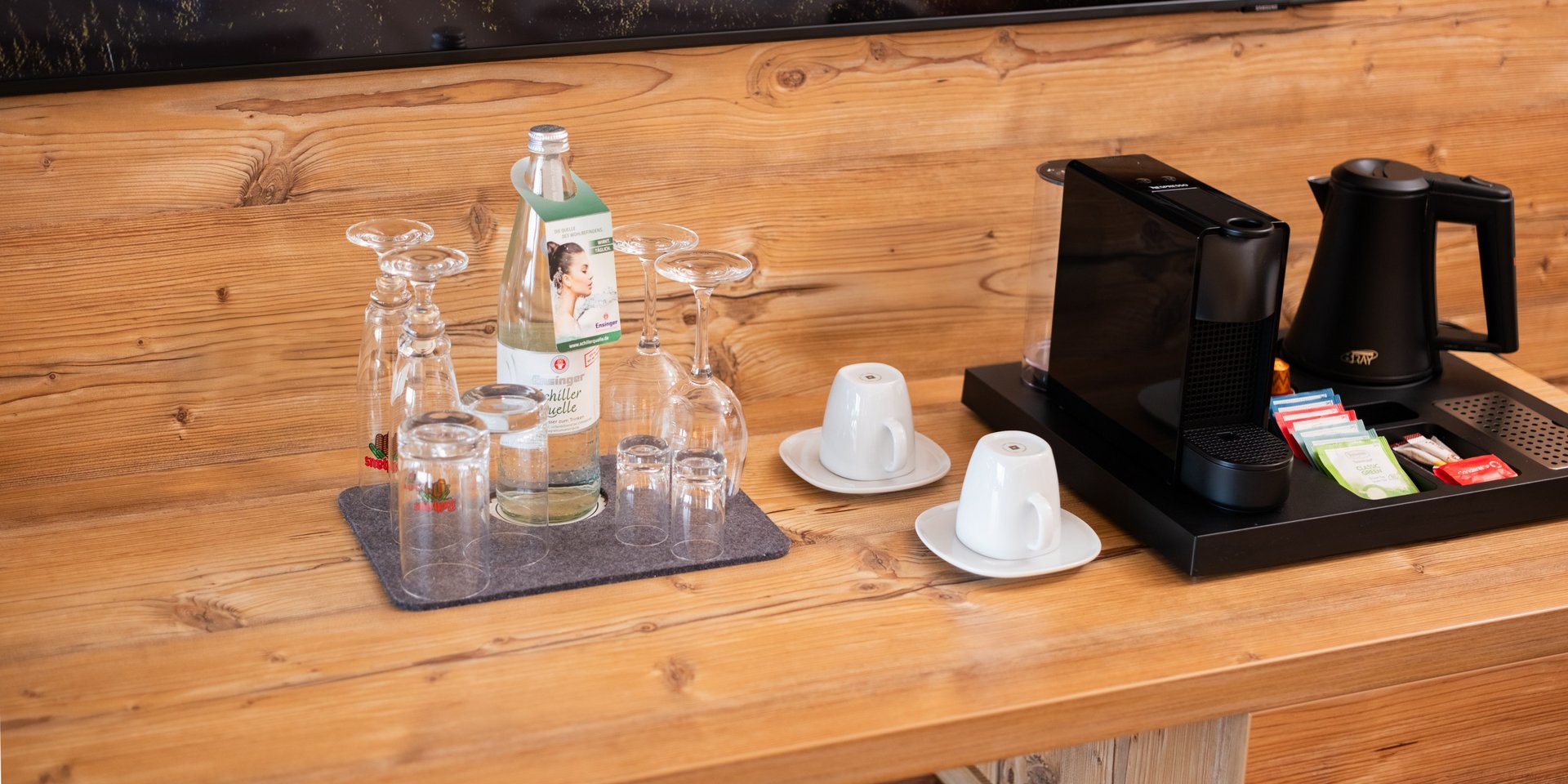 Kaffeestation und Willkommens-Getränke des Hotels Vier Jahreszeiten auf dem Sideboard aus Naturholz im Doppelzimmer Klassik Süd.