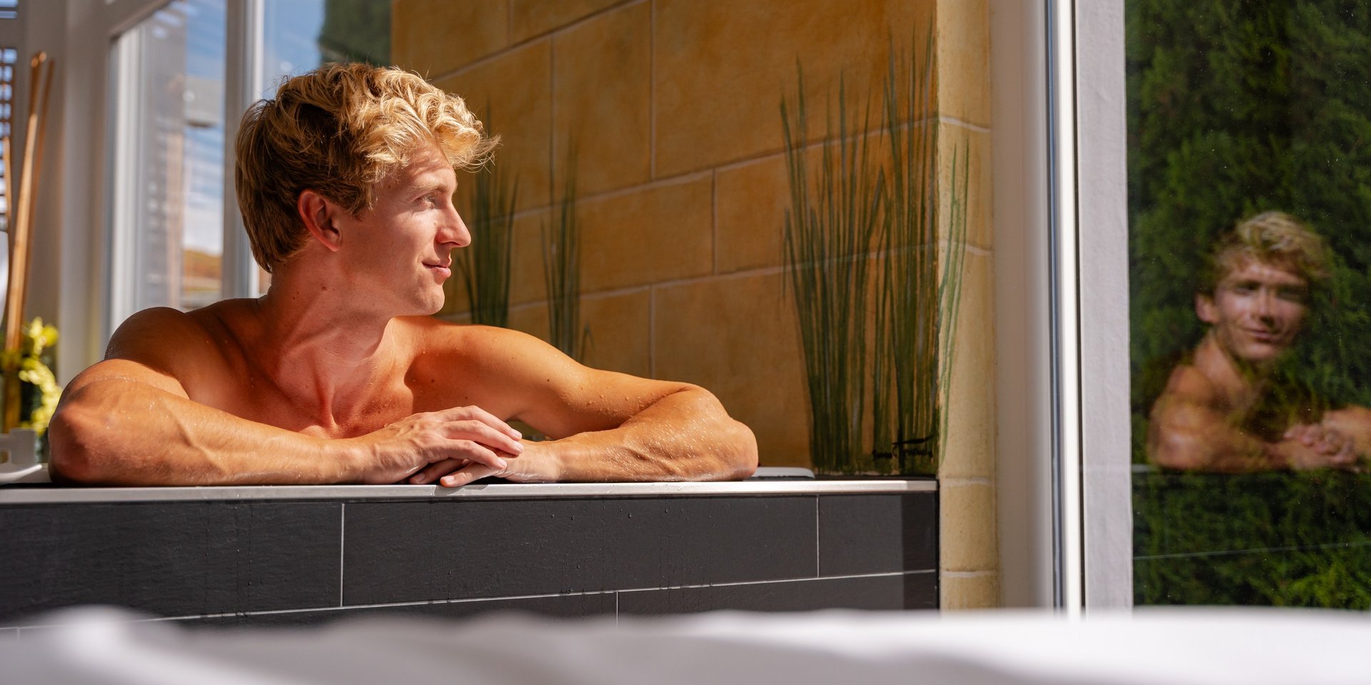 Erholung eines Gastes im warmen Wasser mit Blick in den Schwarzwald-Garten des Hotels Vier Jahreszeiten.