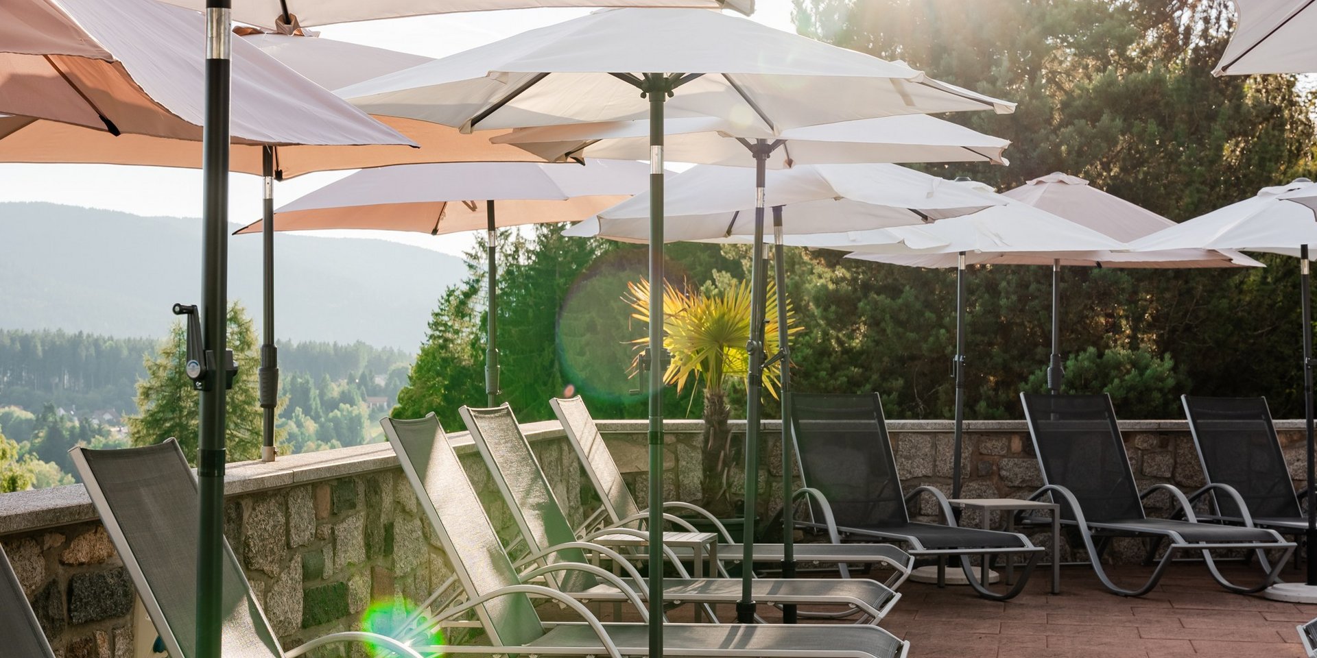 Blick über die gepflegte Poolanlage des Hotels Vier Jahreszeiten am Schluchsee auf die Schwarzwald-Kulisse.