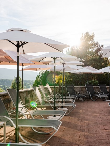 Blick über die gepflegte Poolanlage des Hotels Vier Jahreszeiten am Schluchsee auf die Schwarzwald-Kulisse.