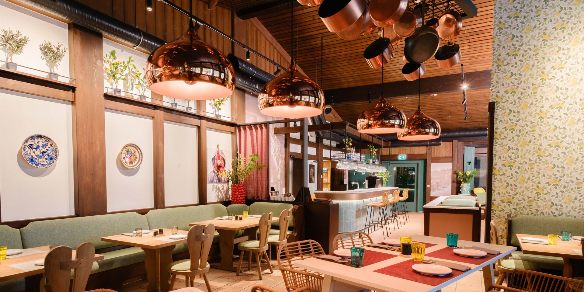 Eingedeckte Tische in einer Nische des Restaurants mit Blick auf die offene Showküche.