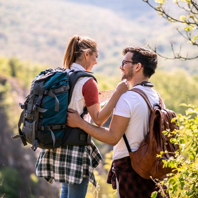 Ein Paar steht auf einem Aussichtspunkt und lächelt sich an