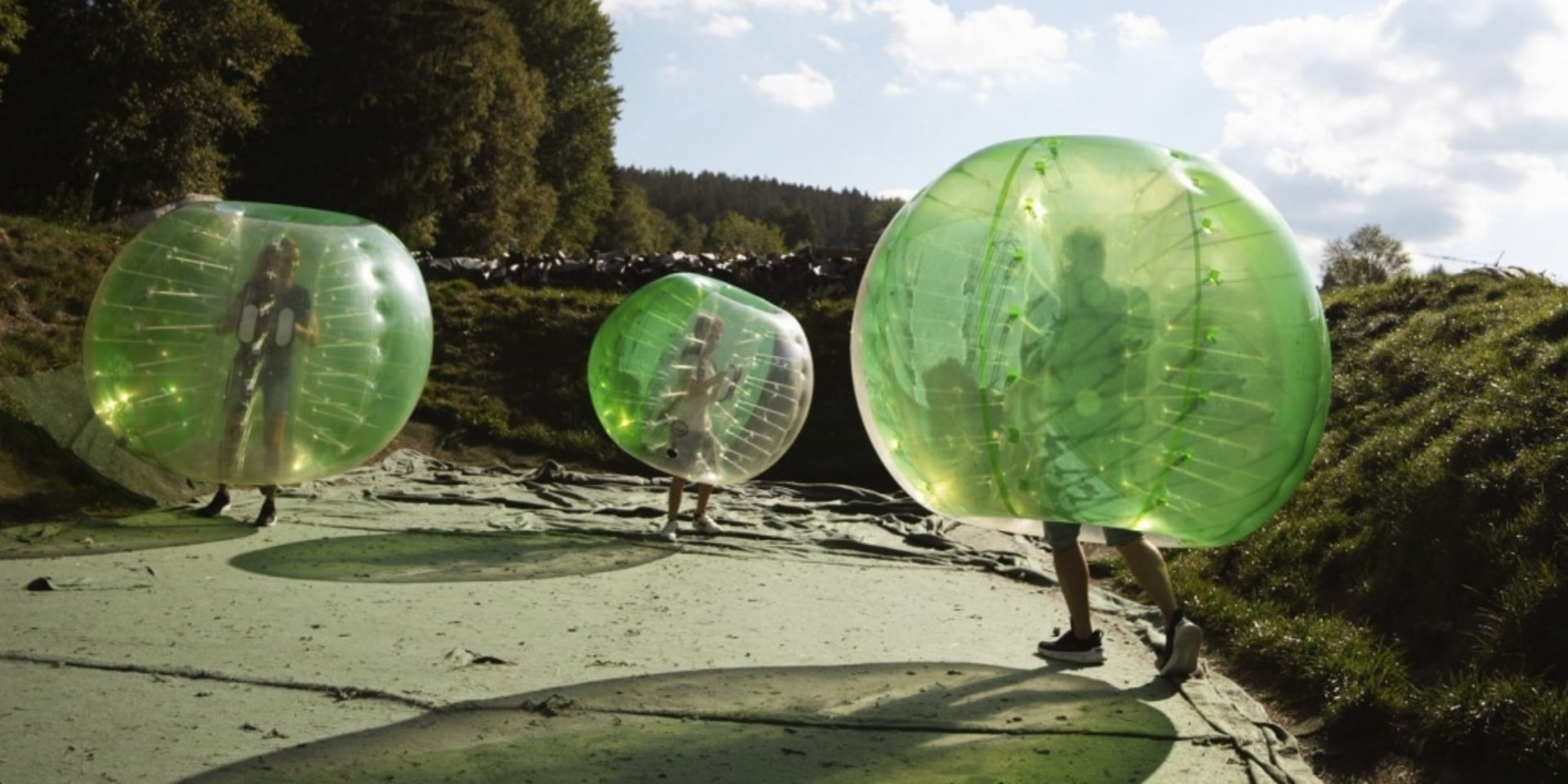 Gäste beim lustigen Bubble-Soccer-Spiel auf dem Sportgelände des Hotels Vier Jahreszeiten.