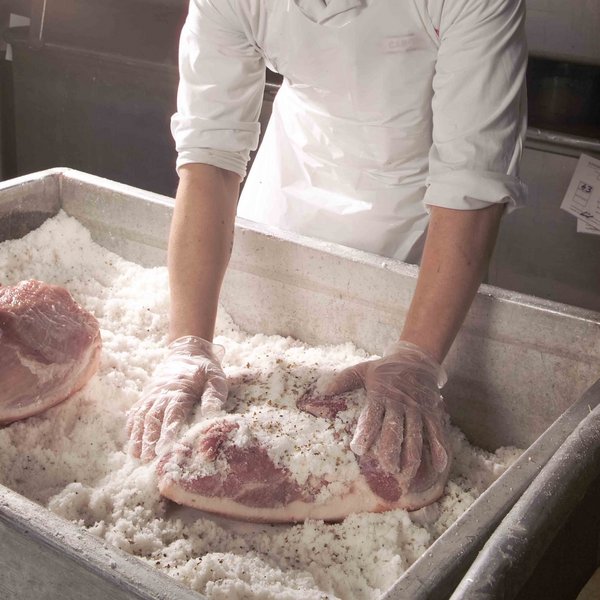 Ein Facharbeiter bei der Salzung von großen Fleischstücken.
