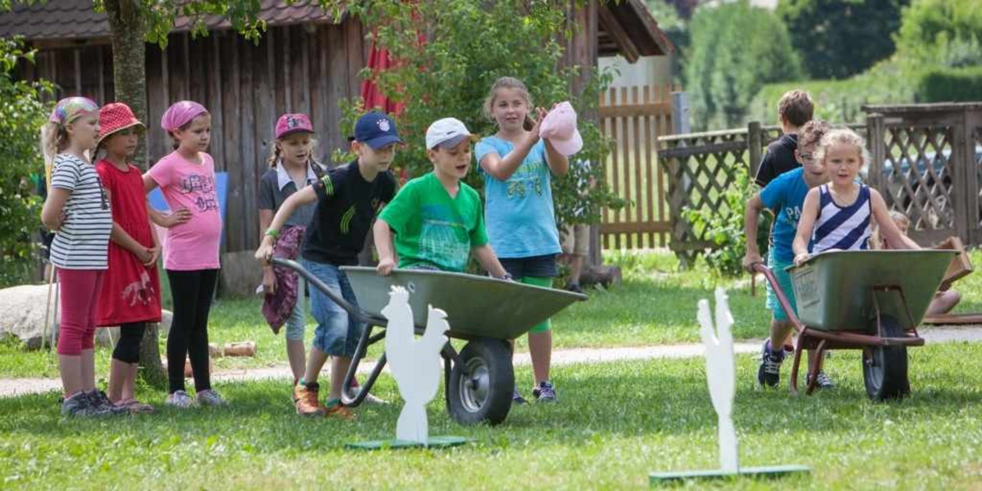 Besucherführung im Freilichtmuseum vor einer Kulisse aus historischen Holzhütten.