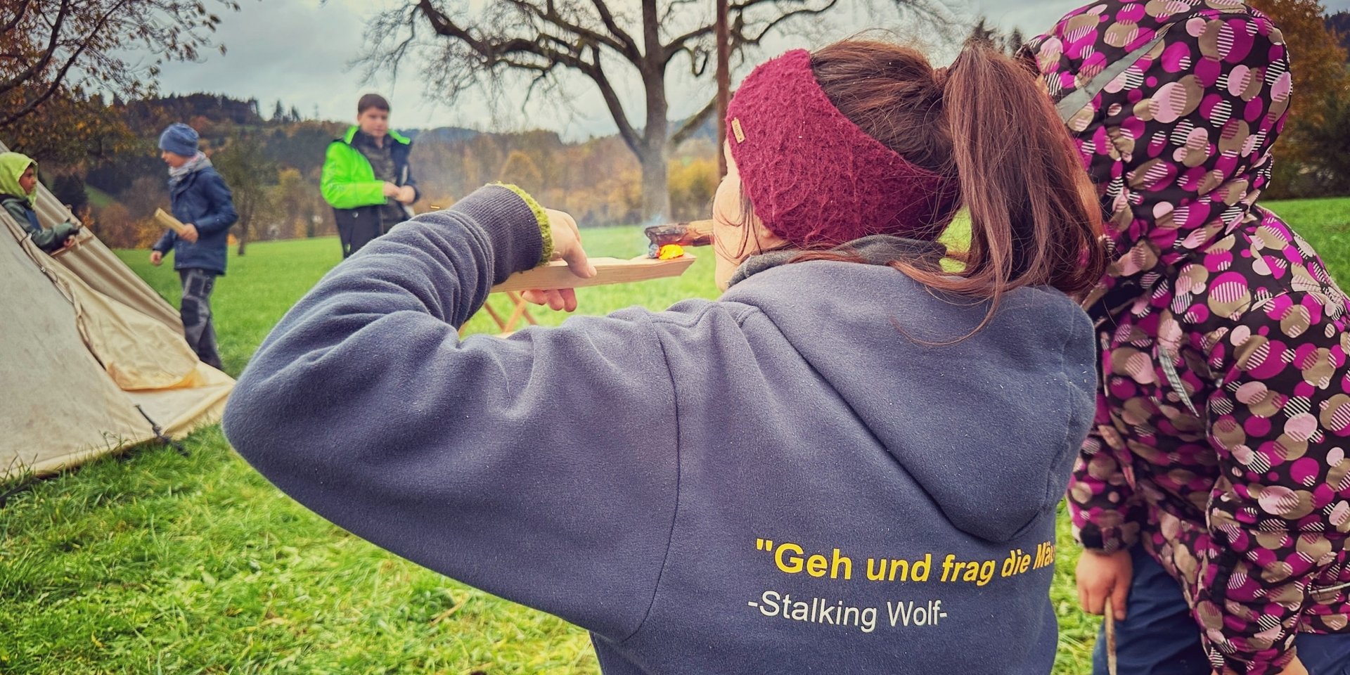 Gäste des Hotels Vier Jahreszeiten beim gemeinsamen Bogenschießen auf einer grünen Wiese im Schwarzwald.