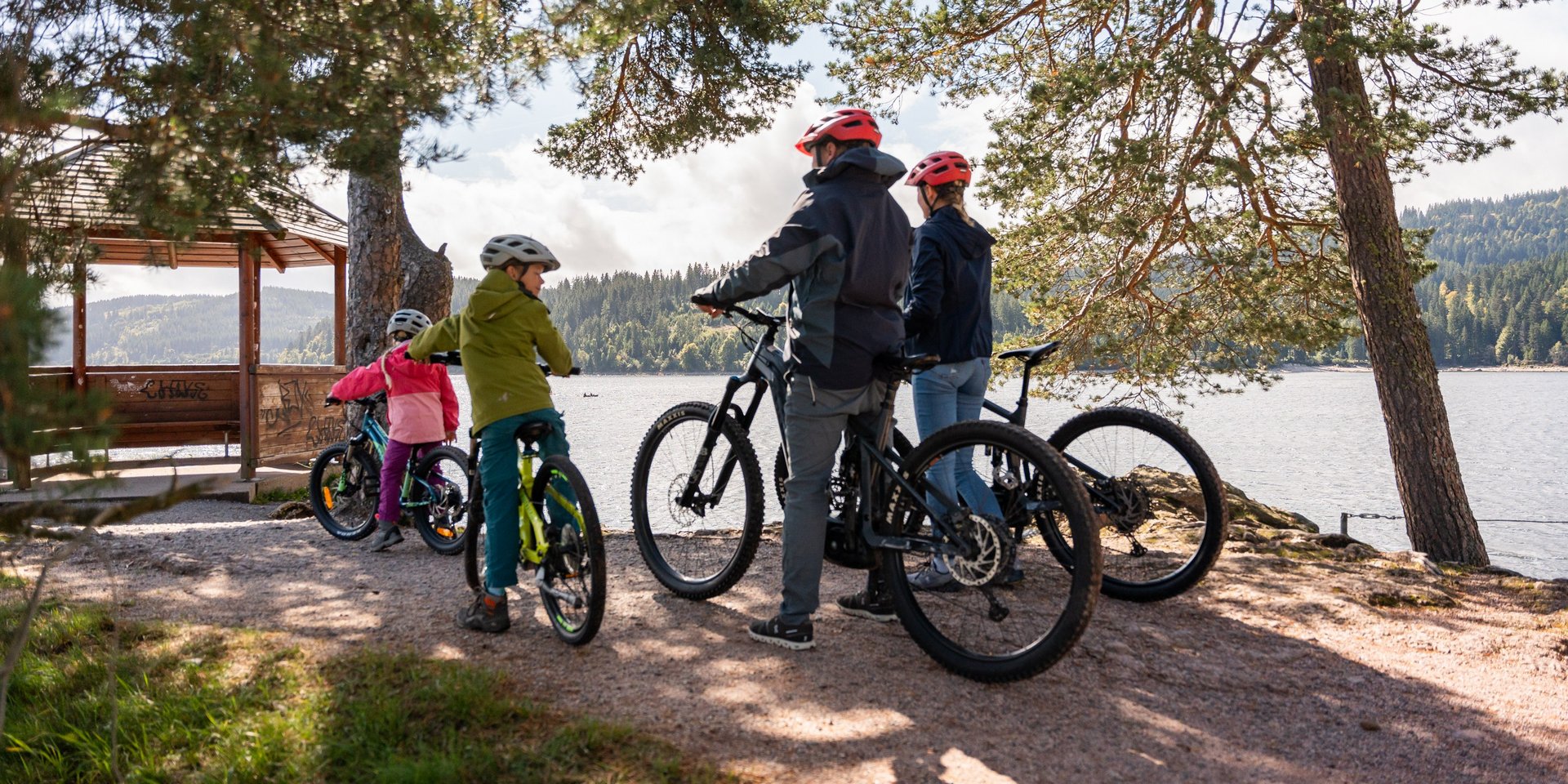 Eine Gruppe von Radfahrern macht Pause an einem Aussichtspunkt mit Blick auf den Schluchsee.