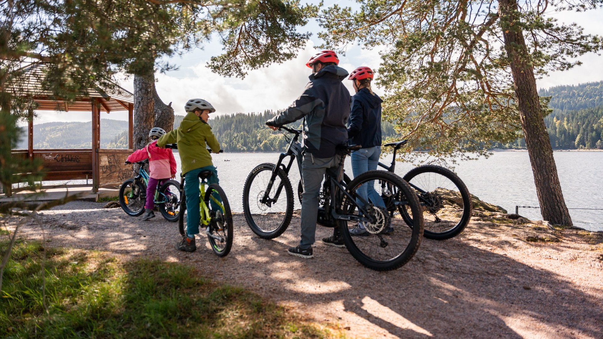 Eine Gruppe von Radfahrern macht Pause an einem Aussichtspunkt mit Blick auf den Schluchsee.