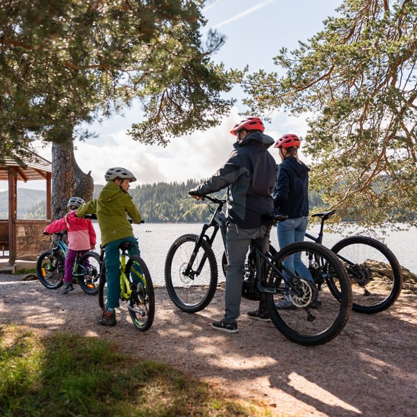 Eine Gruppe von Radfahrern macht Pause an einem Aussichtspunkt mit Blick auf den Schluchsee.