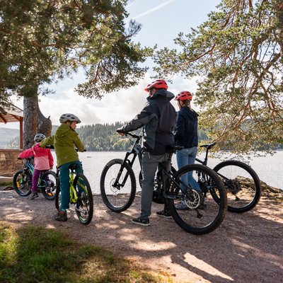 Eine Gruppe von Radfahrern macht Pause an einem Aussichtspunkt mit Blick auf den Schluchsee.