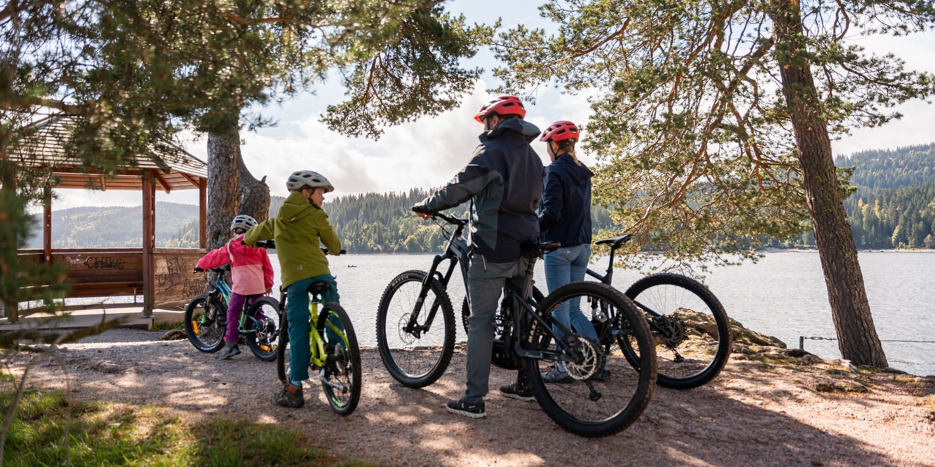 Eine Gruppe von Radfahrern macht Pause an einem Aussichtspunkt mit Blick auf den Schluchsee.