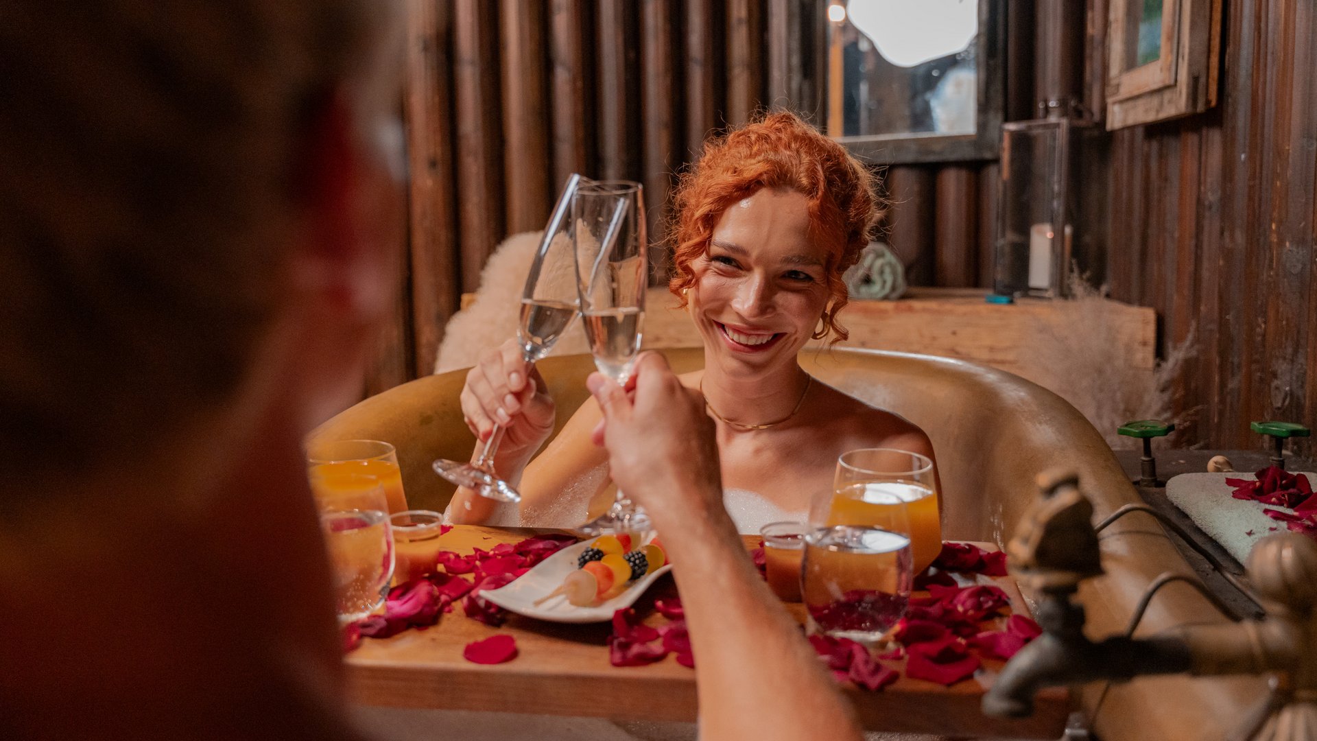 Ein Paar entspannt bei einem romantischen Kaiserbad mit Rosenblüten im Spa des Hotels Vier Jahreszeiten am Schluchsee.