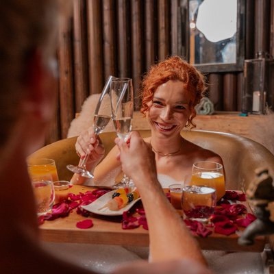 Ein Paar entspannt bei einem romantischen Kaiserbad mit Rosenblüten im Spa des Hotels Vier Jahreszeiten am Schluchsee.
