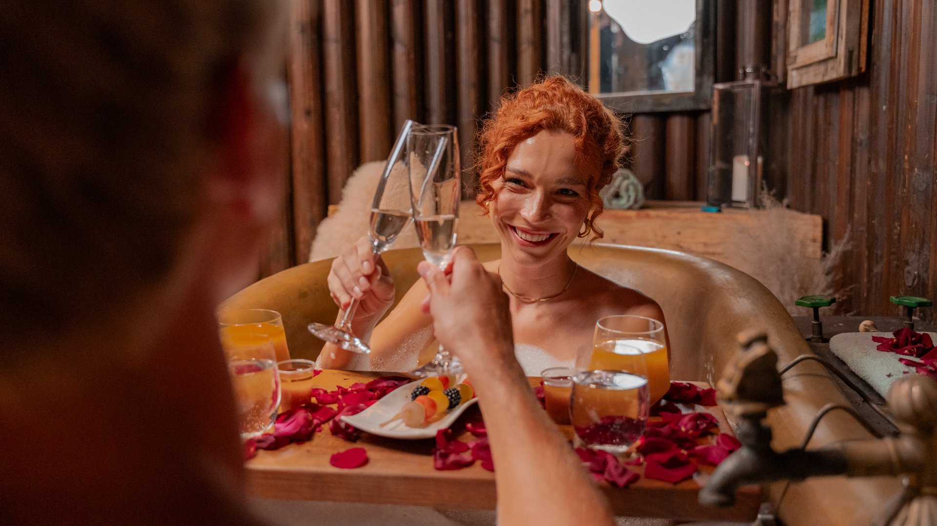 Ein Paar entspannt bei einem romantischen Kaiserbad mit Rosenblüten im Spa des Hotels Vier Jahreszeiten am Schluchsee.