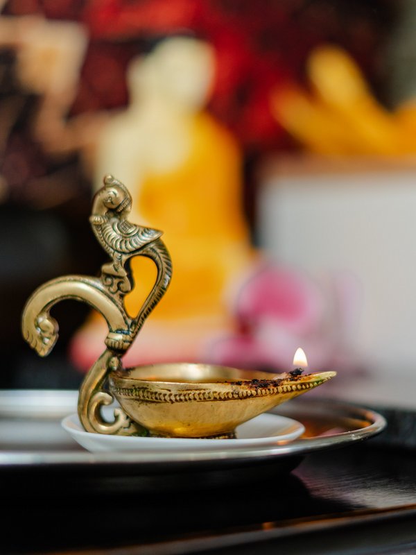 Traditionelle goldene Öllampe auf einem steinernen Tablett als Teil der Ayurveda-Dekoration im Hotel Vier Jahreszeiten im Schwarzwald.
