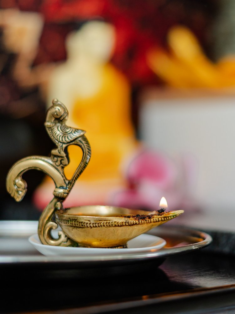 Traditionelle goldene Öllampe auf einem steinernen Tablett als Teil der Ayurveda-Dekoration im Hotel Vier Jahreszeiten im Schwarzwald.