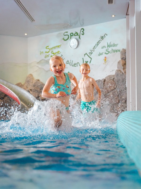 Kinder planschen vergnügt im flachen Wasser des Hallenbades im Hotel Vier Jahreszeiten am Schluchsee.