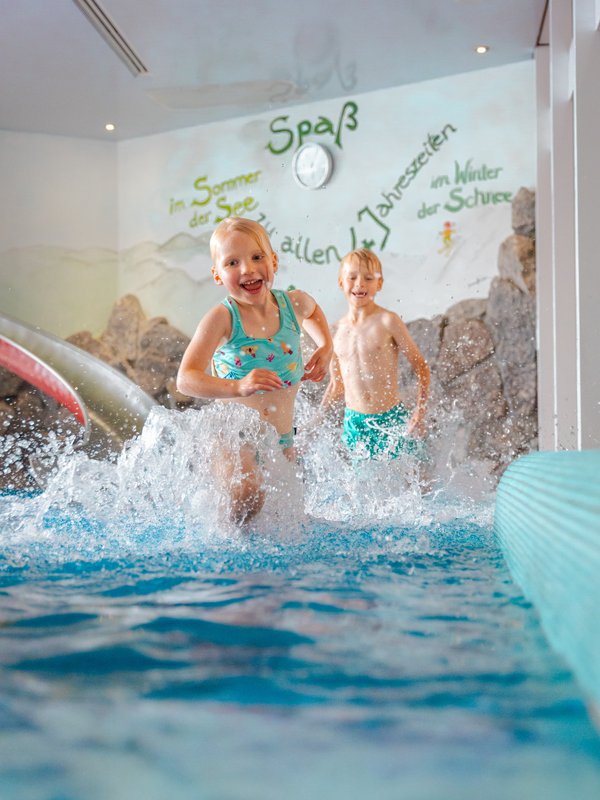 Kinder planschen vergnügt im flachen Wasser des Hallenbades im Hotel Vier Jahreszeiten am Schluchsee.