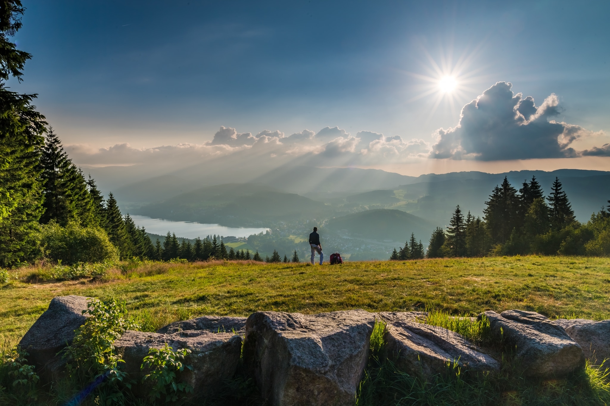Wanderer auf einem Berg im Schwarzwald mit Blick auf einen See
