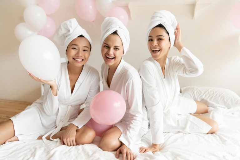 Frauen mit Bademänteln und Luftballons auf deinem Bett