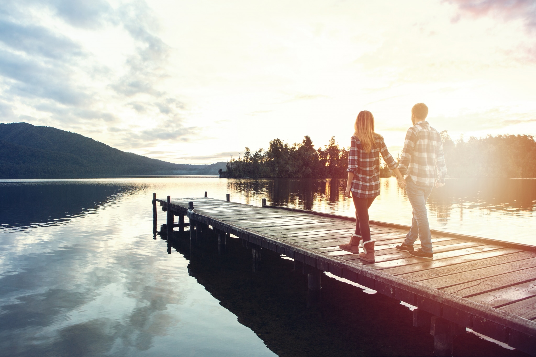 Paar spaziert auf dem Bootssteg am See