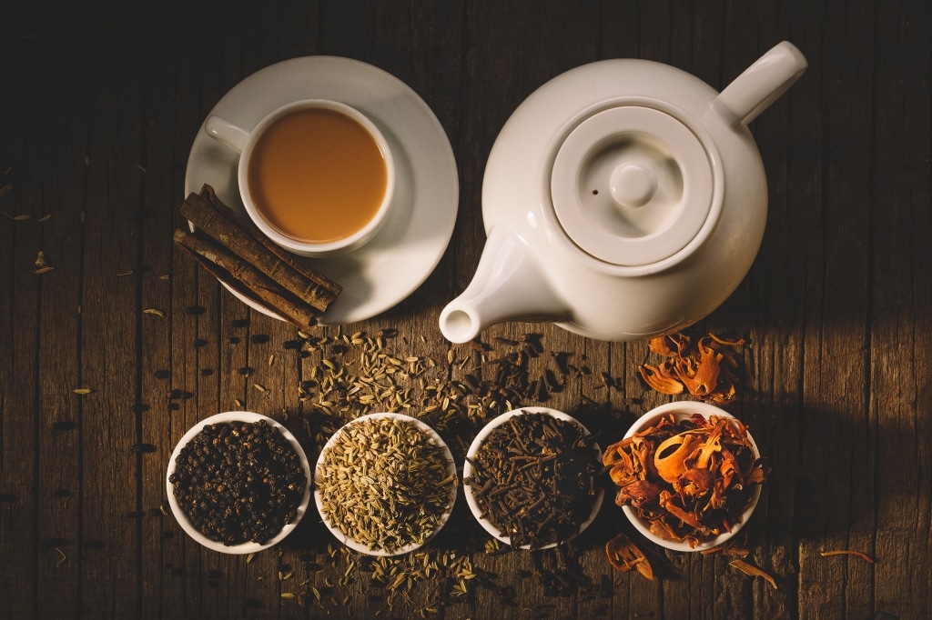 Teetasse und -kanne mit Gewürzen